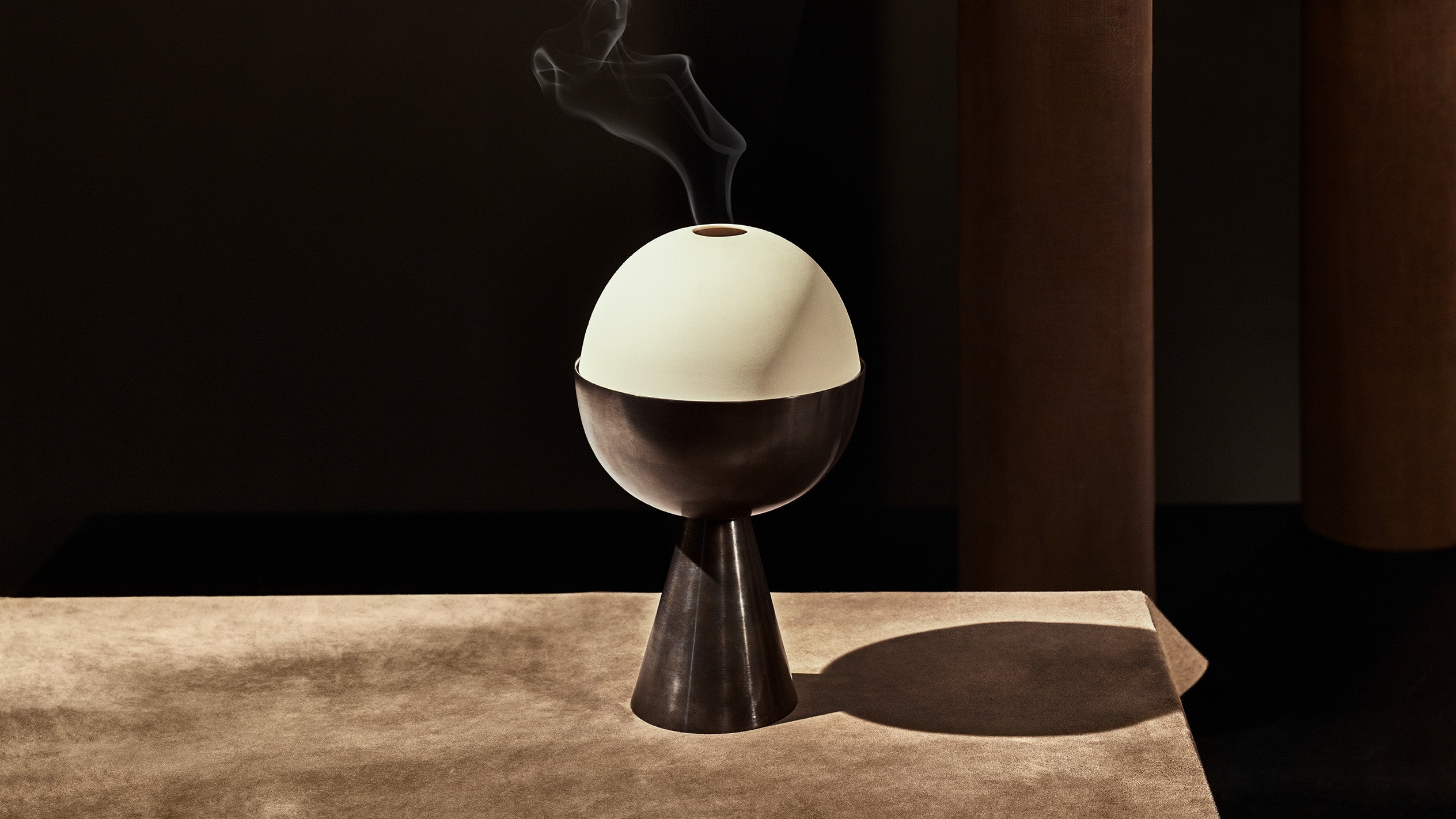 Incense smoke emitting from the top of a decorative object in Blackened Brass finish.