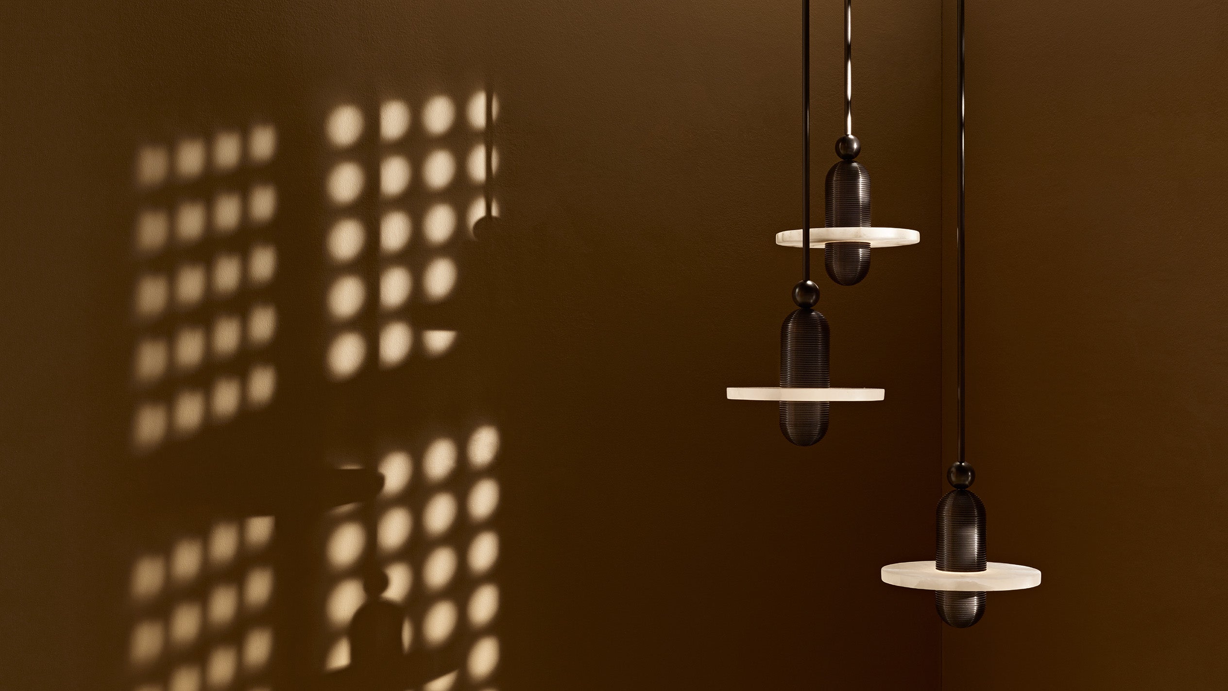 A trio of MEDIAN : MONO ceiling pendants in varying heights. 