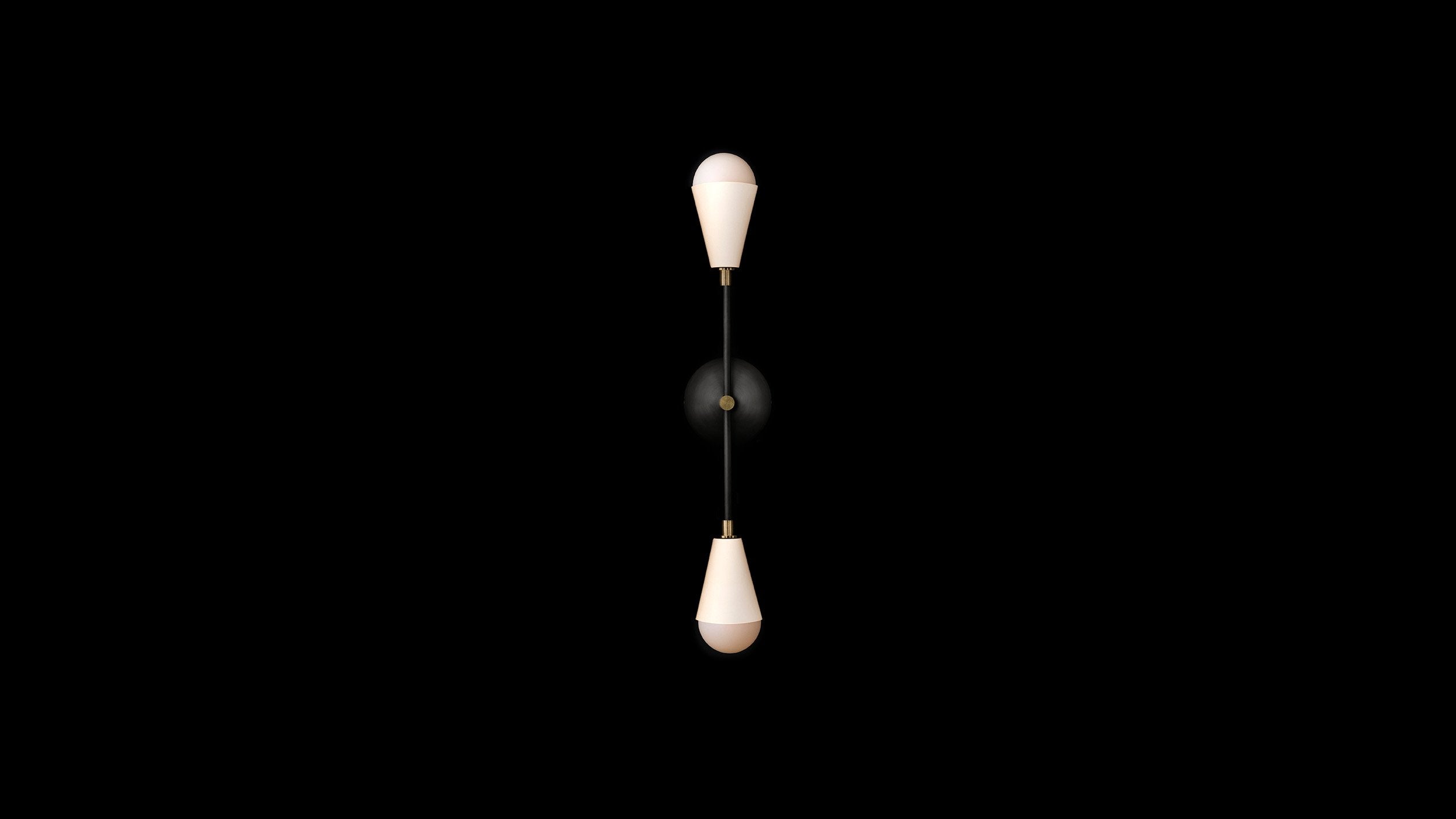 TRIAD : 2 sconce in Blackened Brass and Aged Brass finish with Porcelain, mounted vertically to a black wall. 