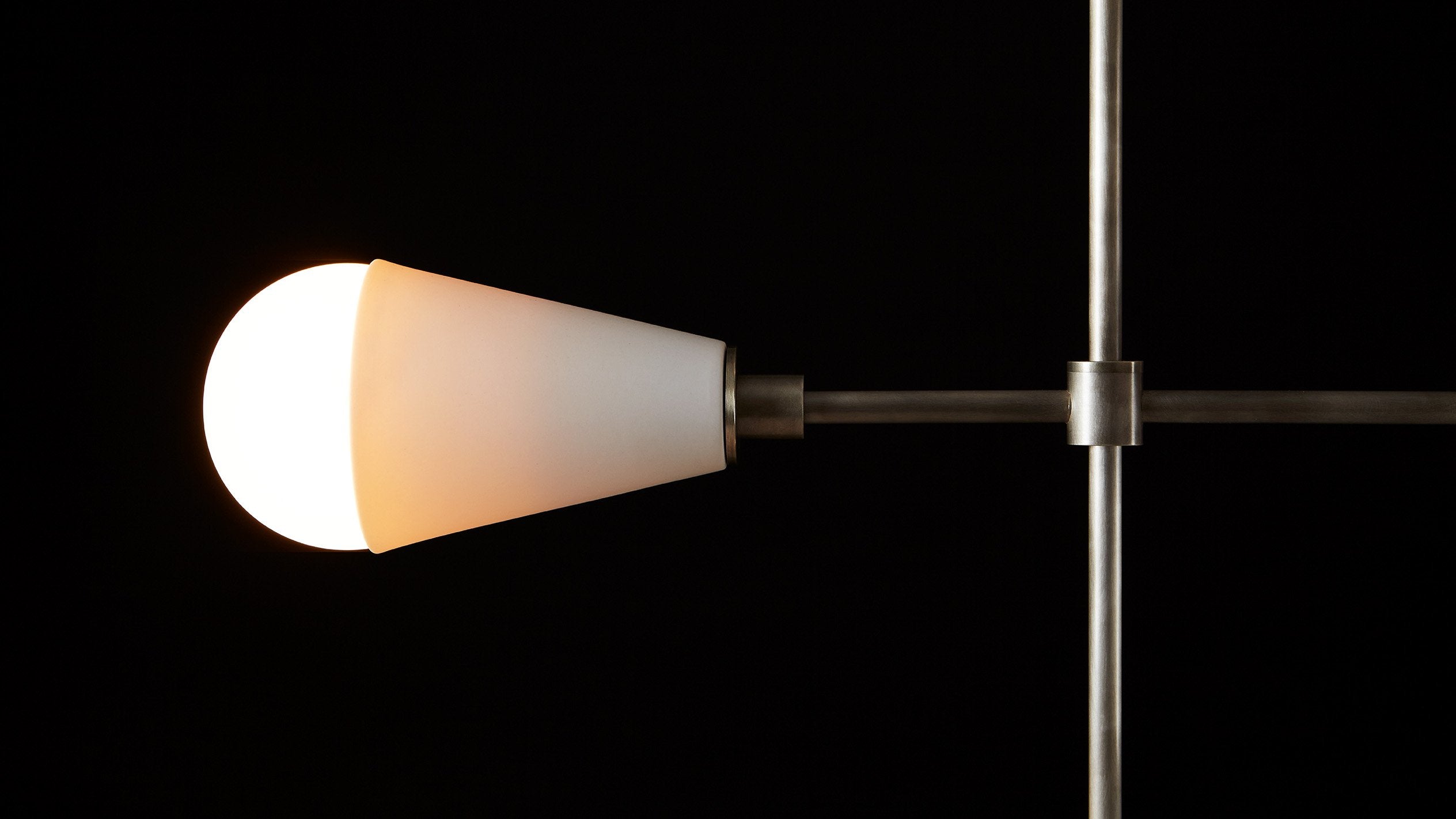 Close up of an illuminated TRIAD : 9 ceiling pendant showing details of the Aged Brass finish, Tarnished Silver finish and Porcelain. 