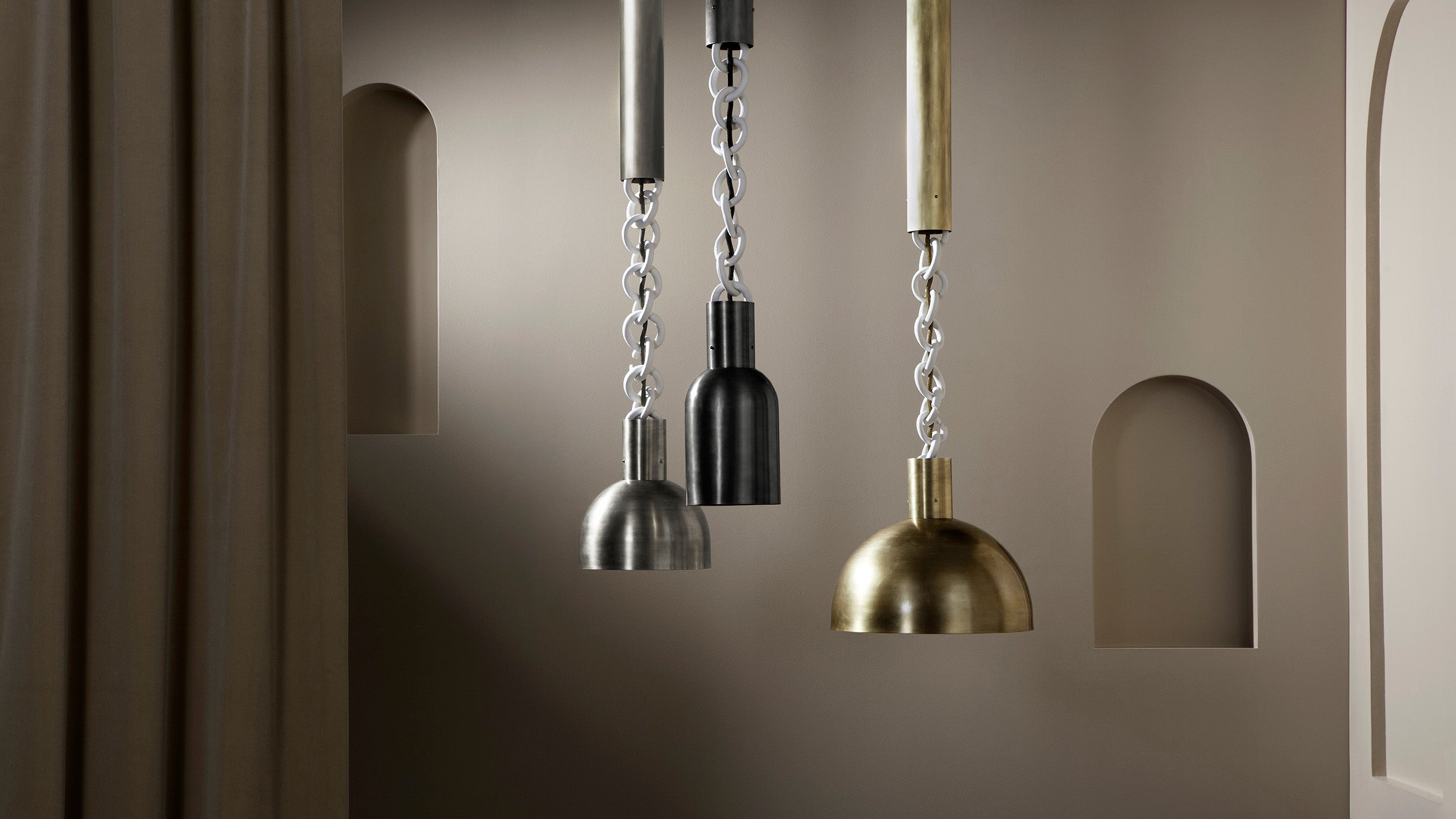 A trio of LINK ceiling pendants in an assortment of sizes, heights and metal finishes. 
