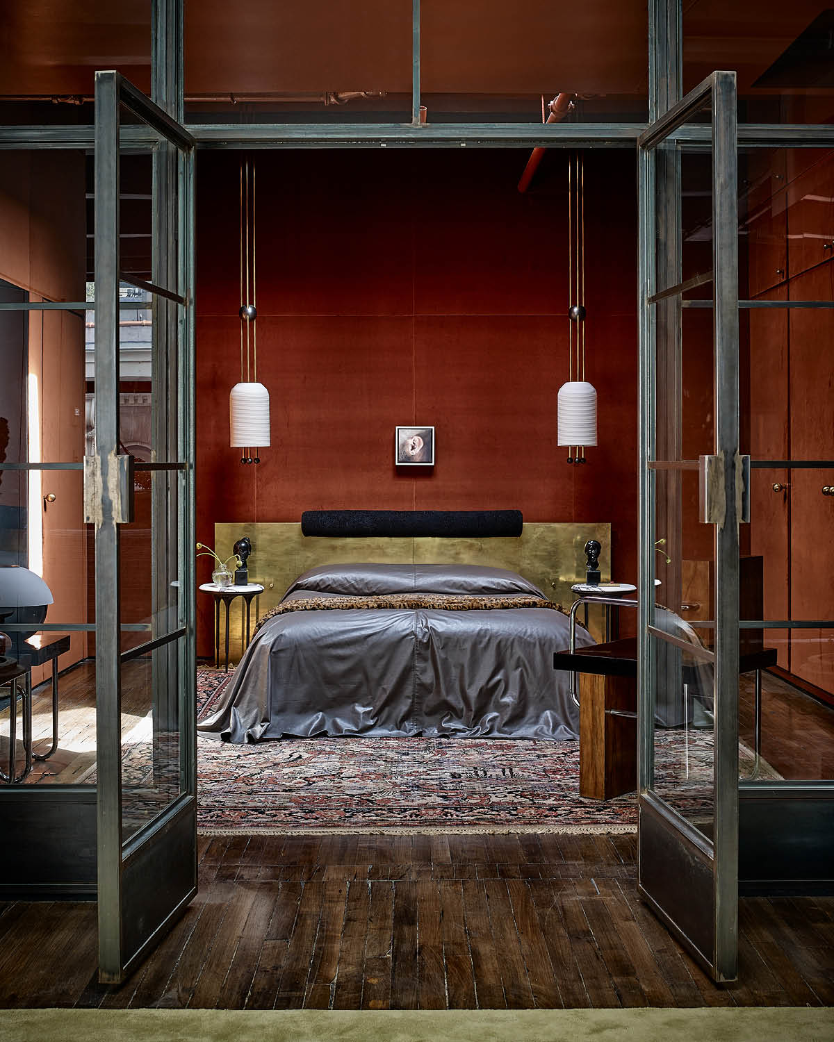 A pair of LANTERN ceiling pendants hanging either side of a bed at the 20th Street residence.