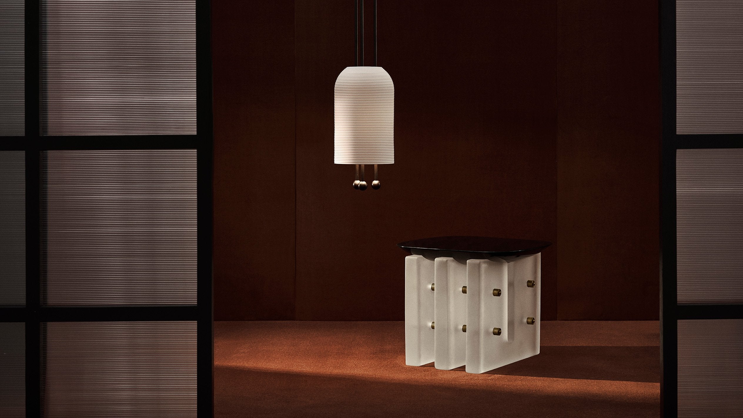 SEGMENT side table in Black Lacquer with a LANTERN ceiling pendant hanging overhead.