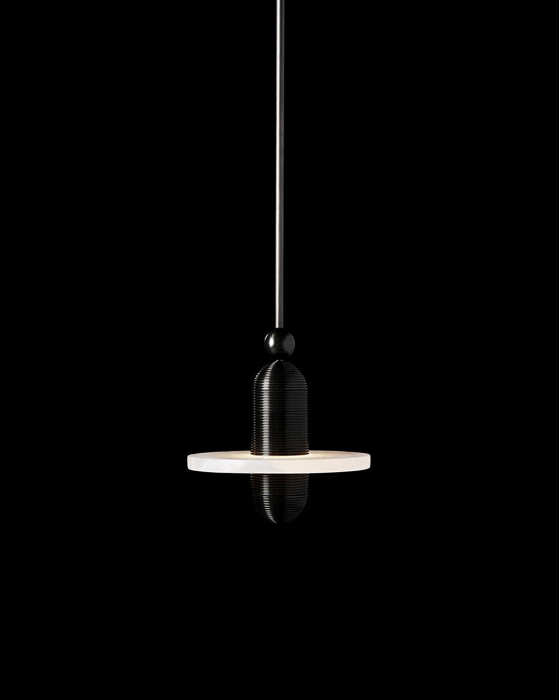 MEDIAN : MONO ceiling pendant in Blackened Brass finish hanging against a black background. 