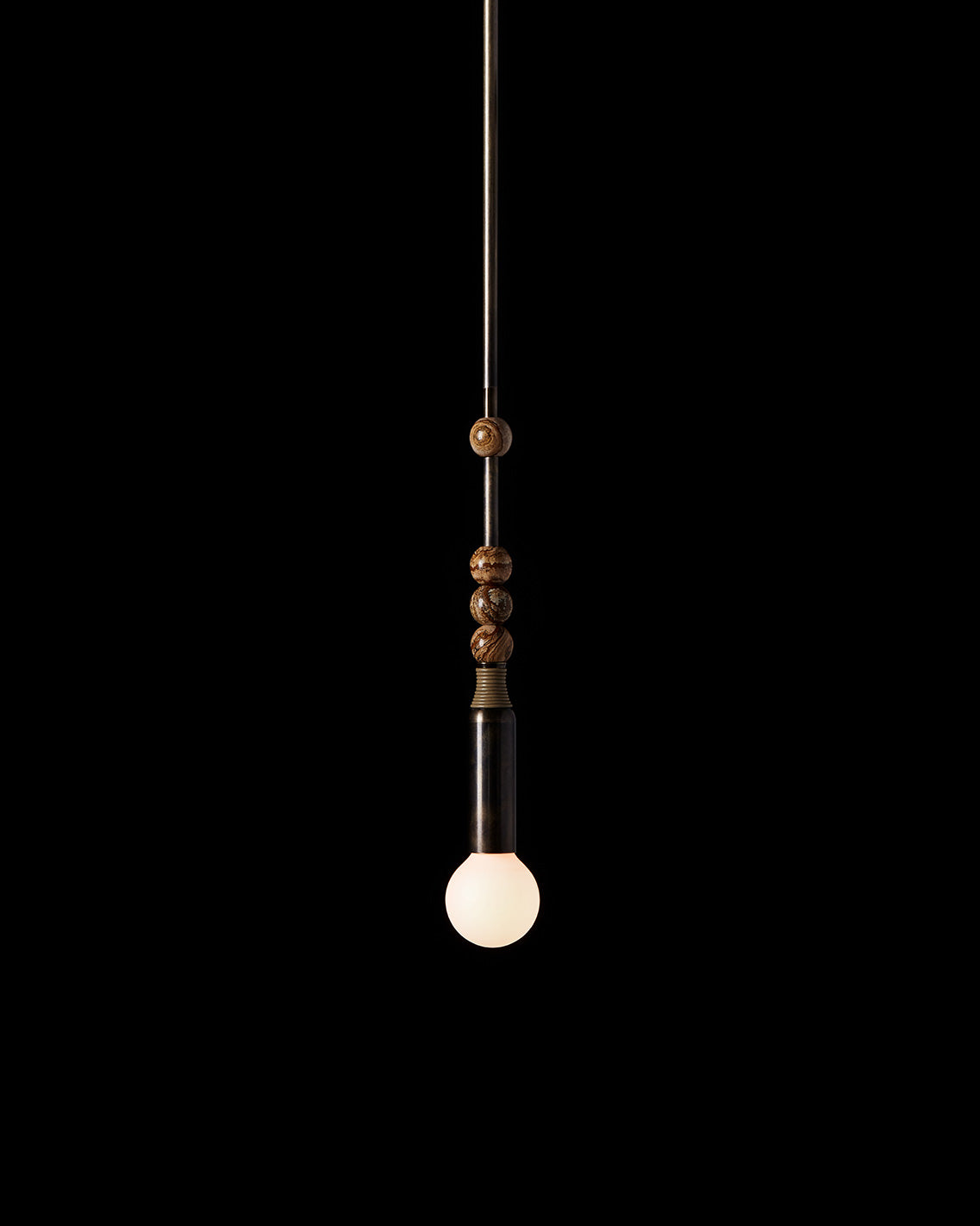 An illuminated TALISMAN : 1 ceiling pendant hanging against a black background. 