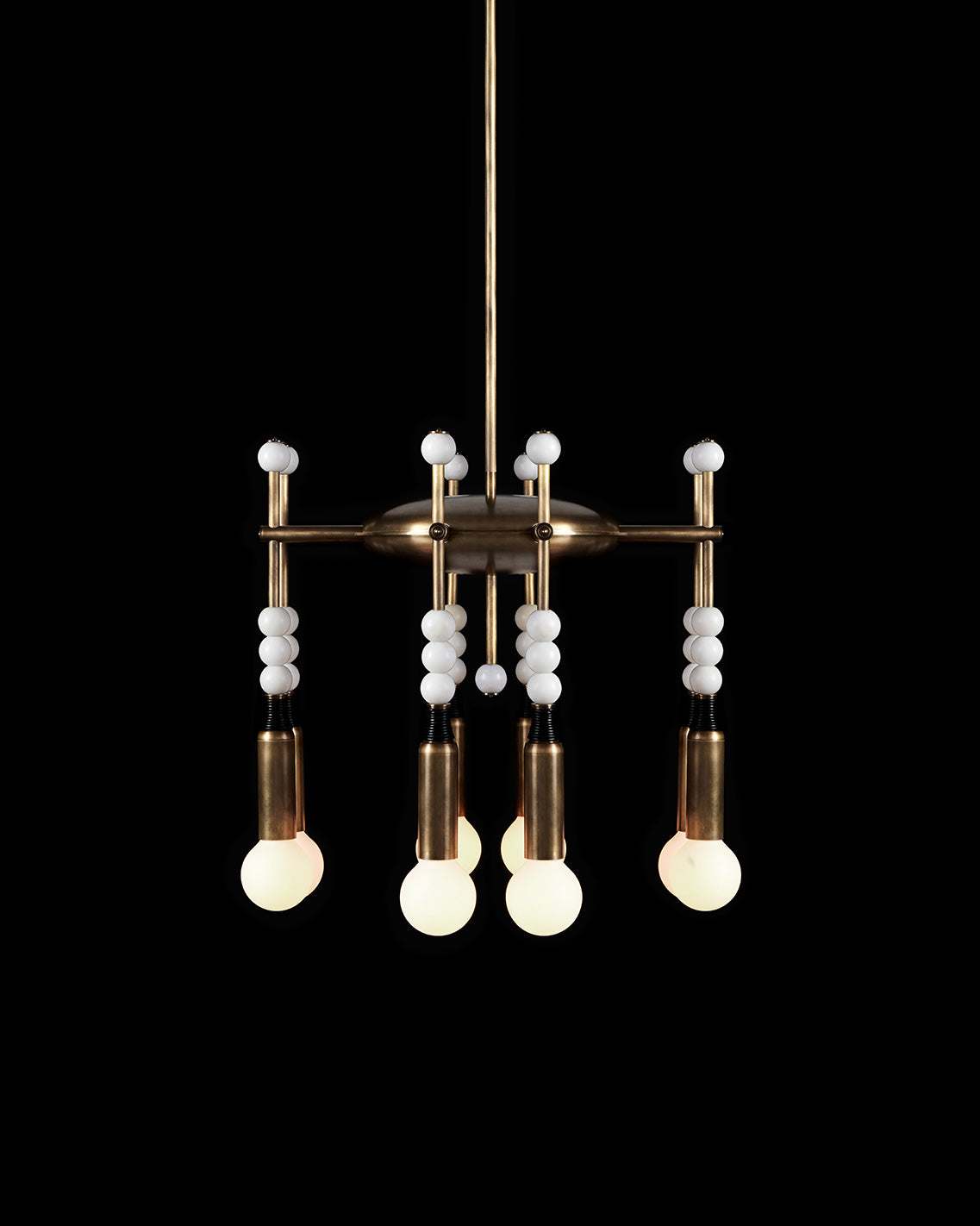 TALISMAN : 8 chandelier in Aged Brass and Black Leather with White Jade stone, against a black background. 