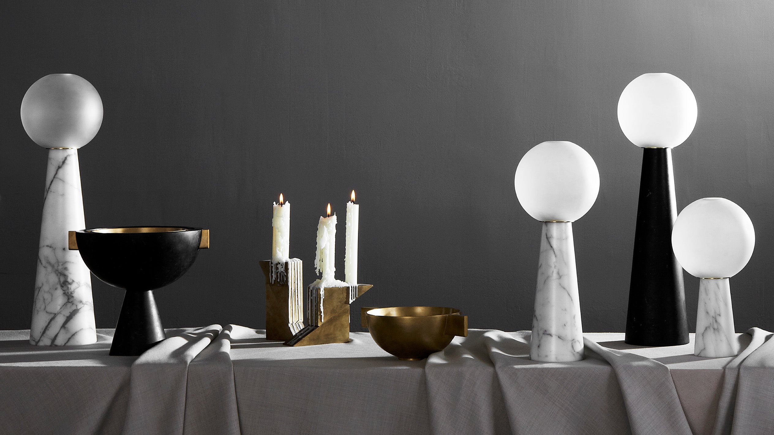 A table decorated with a number of APPARATUS decorative objects, including NEO lanterns, CANDLE BLOCKS and objects used for burning incense.