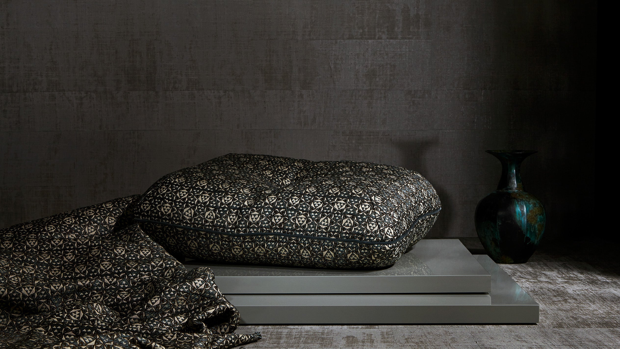 An upholstered cushion and draped fabric.