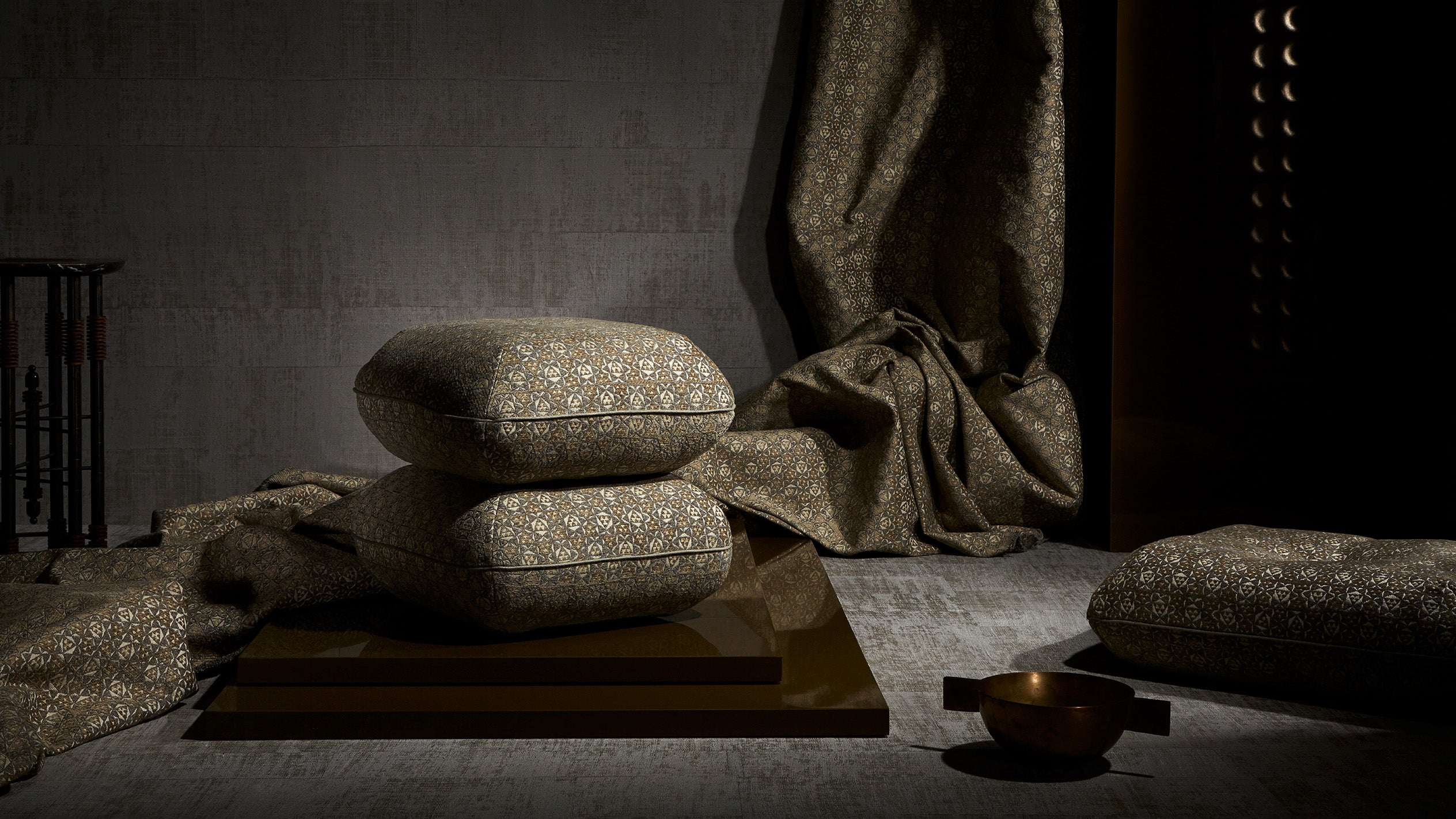 An assortment of upholstered cushions, decorative objects and drapery. 