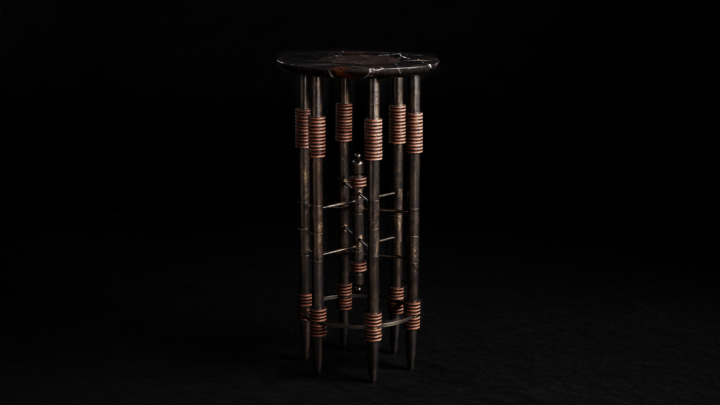 PARS cocktail table in Oil Rubbed Bronze with Nero Gold Marble and Ebene Leather, against a black background.