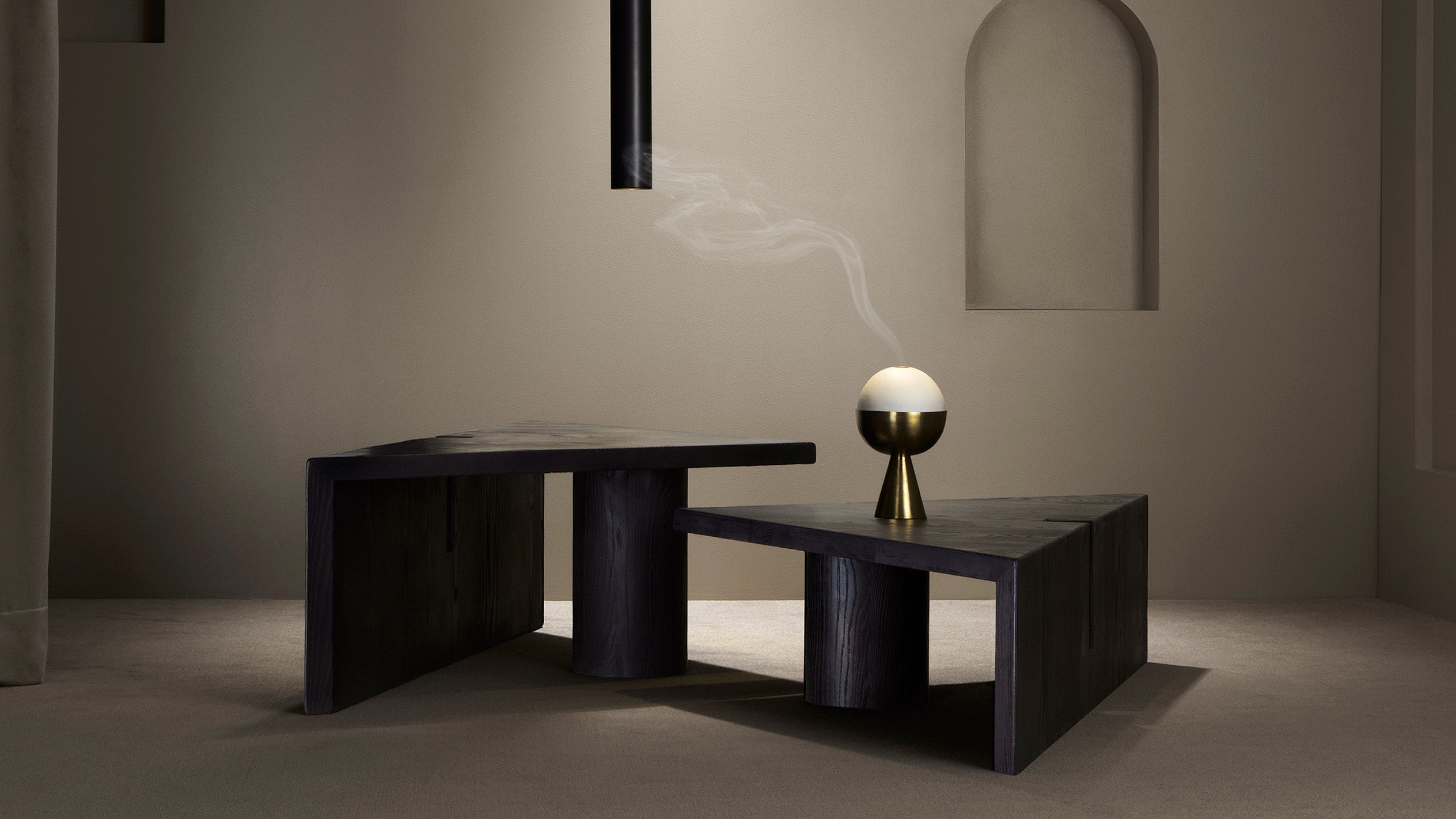 A decorative object used for burning incense sits on top of a modular PORTAL coffee table in Blackened Ash Wood. 