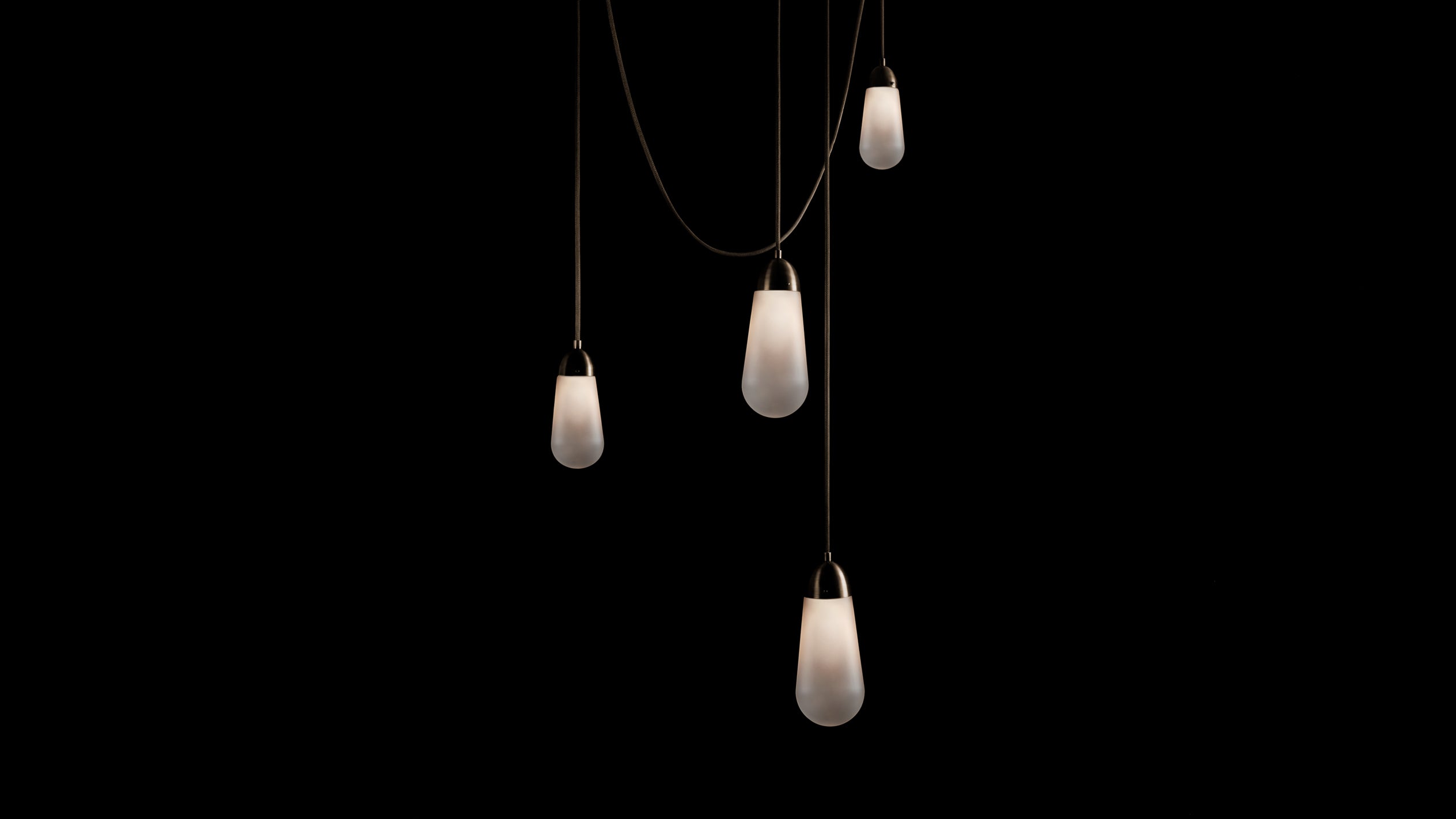 A LARIAT installation, comprised of four ceiling pendants in an assortment of sizes and heights, in Oil-Rubbed Bronze finish. 