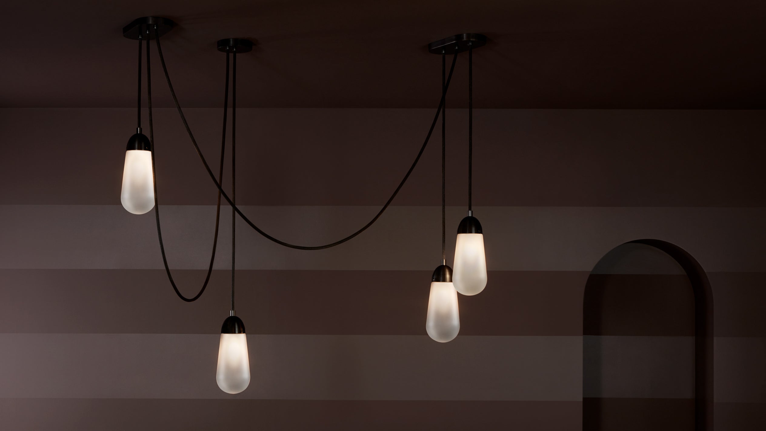 A LARIAT installation, comprised of four ceiling pendants in varying heights, in Oil-Rubbed Bronze finish. 