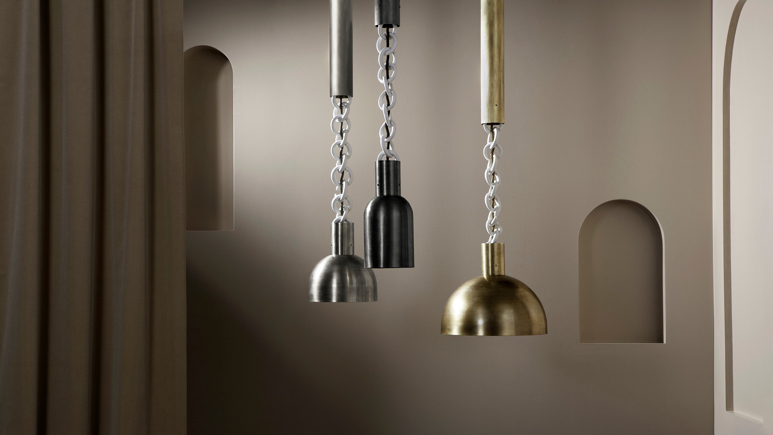 A trio of LINK ceiling pendants in an assortment of sizes and metal finishes.