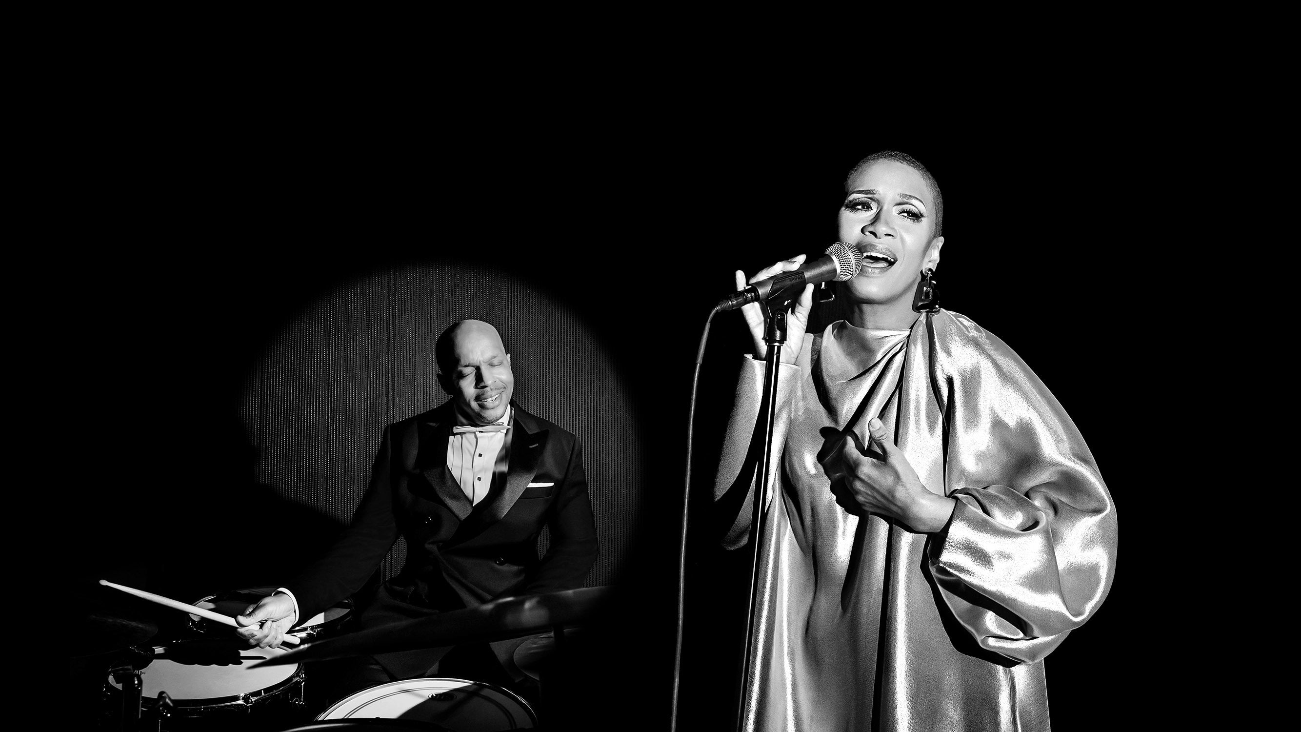 Marcus Baylor playing the drums and Jean Baylor singing