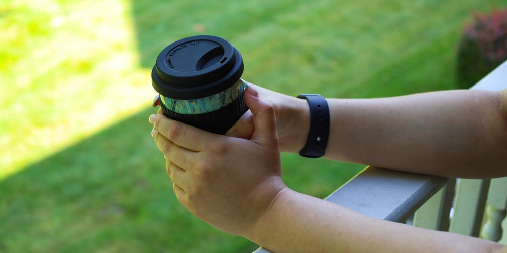 holding birds egg travel mug outside