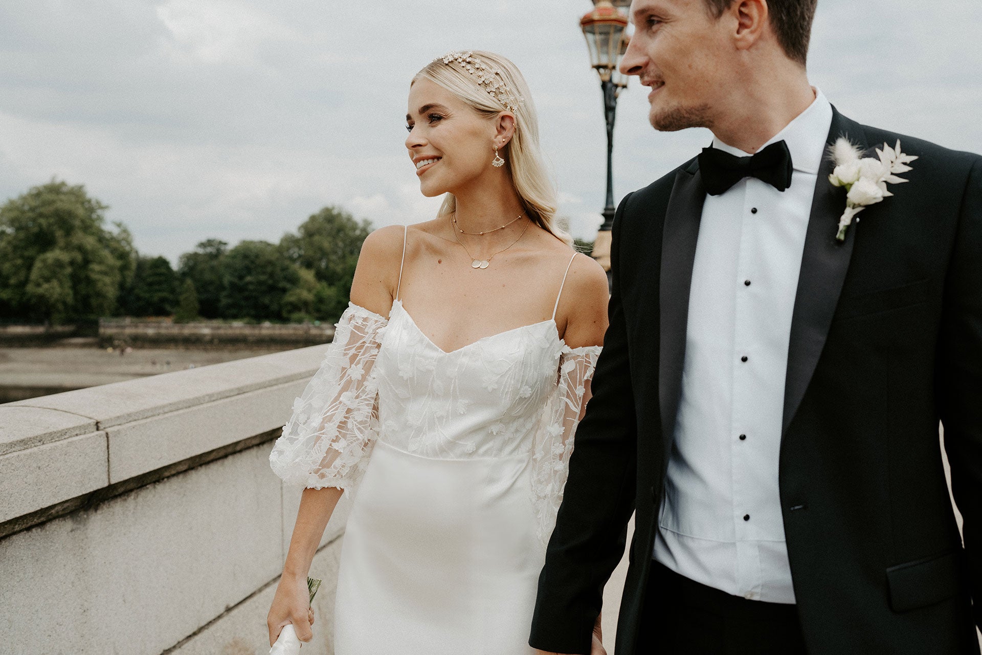 The bride and groom walking over Putney Bridge