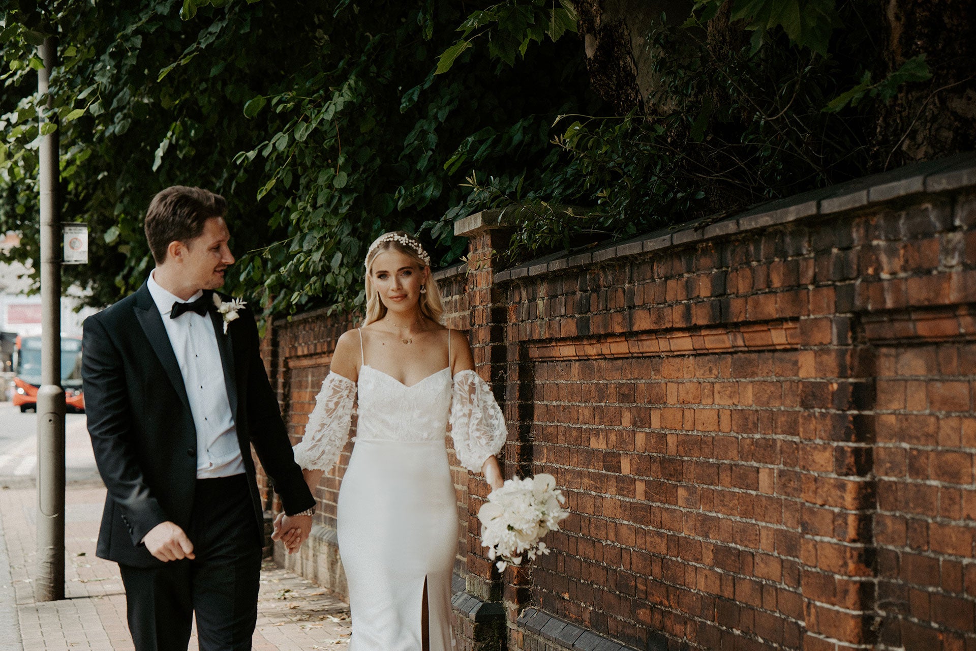 Bride and groom outside Winchester House in Putney. The bride is wearing the Florence Wedding Dress designed by Putney-based bridal designed, Constellation Ame