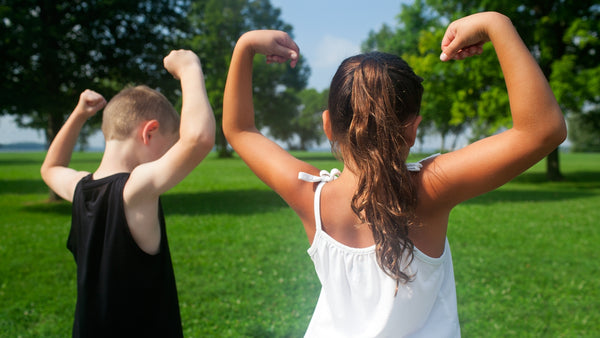 young girl and boy showing strong arms