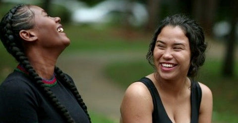 Two women outdoors laughing in conversation