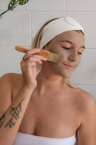 Woman applying Mayella Hydrate Masque with natural fibre brush to her face as part of a skincare routine