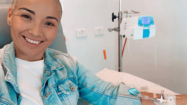 Lorena smiling at the camera while receiving chemotherapy