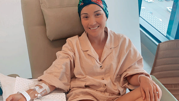 Lorena smiling at the camera while receiving chemotherapy treatment