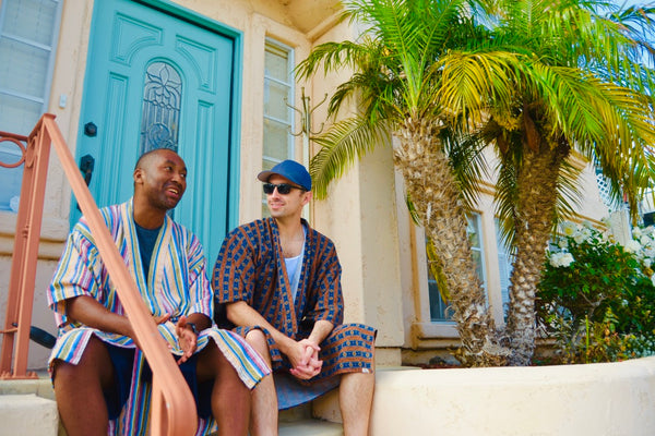 two men sitting on stoop wearing robe as swim cover up