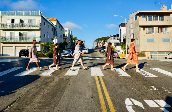 five friends walking across crosswalk wearing robes as swim cover ups