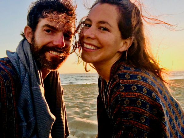 man and woman watching sunset wearing robes as swim cover ups