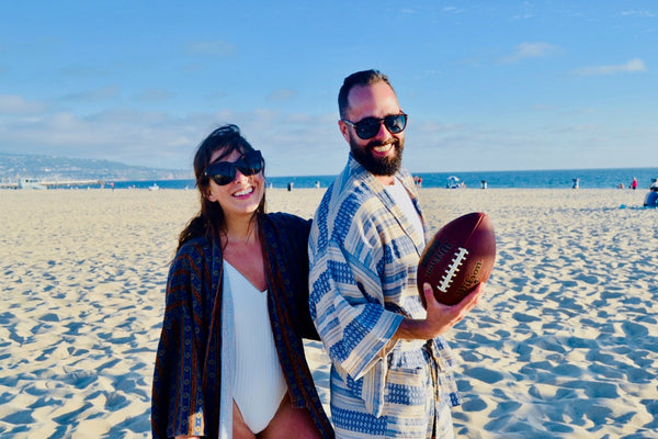 man and woman playing football, wearing robe as swim cover up