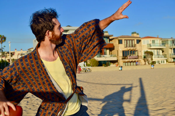 man throwing football wearing robe as swim cover up