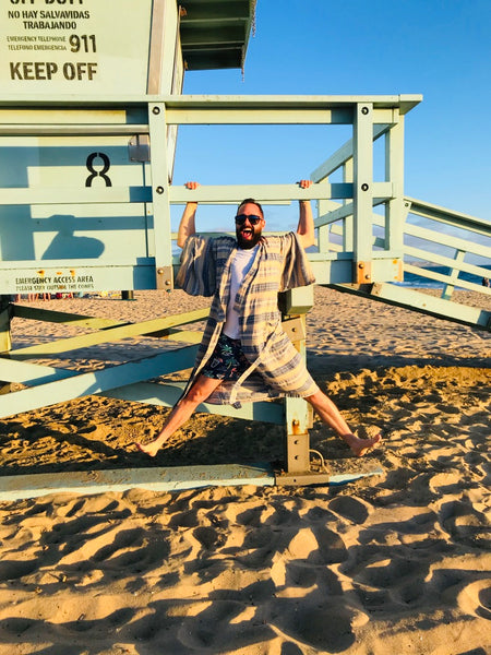 man at lifeguard stand wearing robe as swim cover up