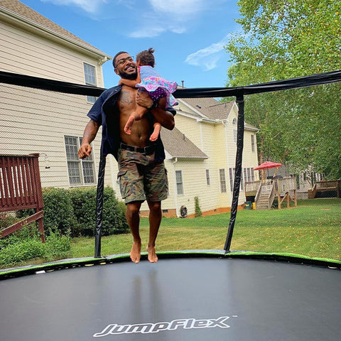 Dad and his child jumping and playing on a Jumpflex trampoline