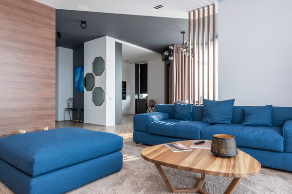 Blue cushions on a blue couch with a wooden table