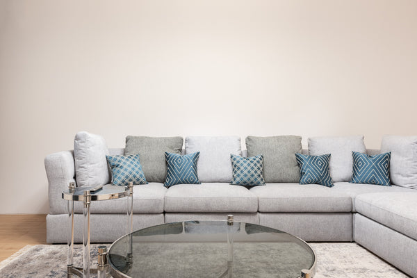 Patterned and Neutral-coloured cushions on an L-shaped white sofa