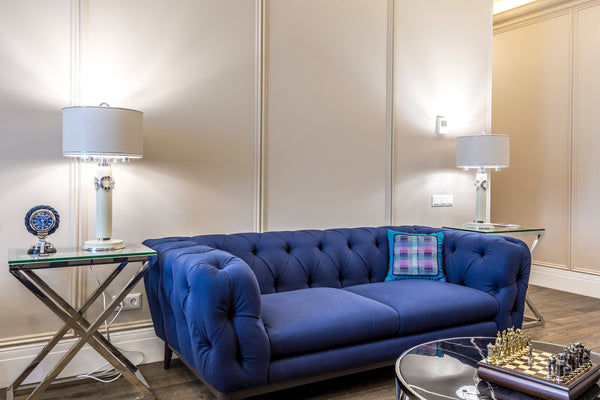 Patterned cushion on a tufted blue sofa