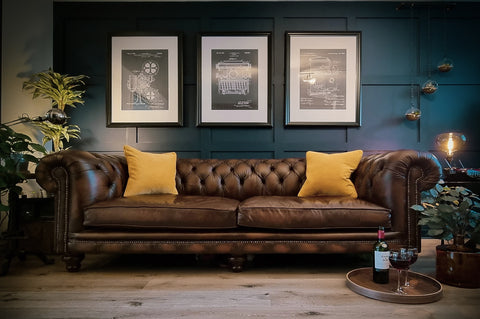 Brown leather sofa with yellow cushions in dark blue room 