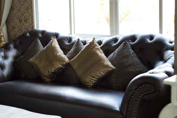 Shiny Throw Pillows on a Black Leather Sofa