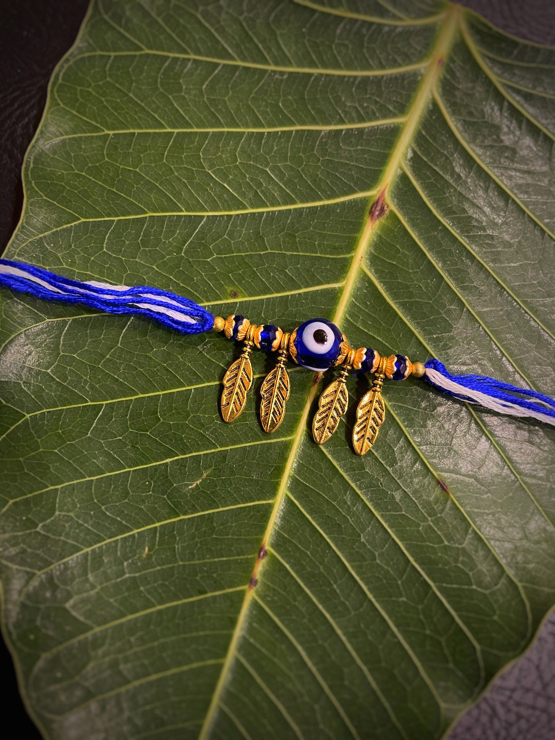 image for Beautiful Designer Evil Eye Rakhi Leaf Designs With White/Blue Thread Rakhi For Raksha Bandhan