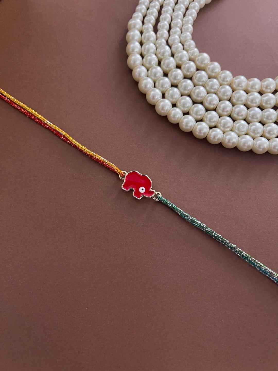 image for Designer Rakhi Red Elephant Evil Eye Charm With Multicolor Thread Rakhi For Rakshabandhan