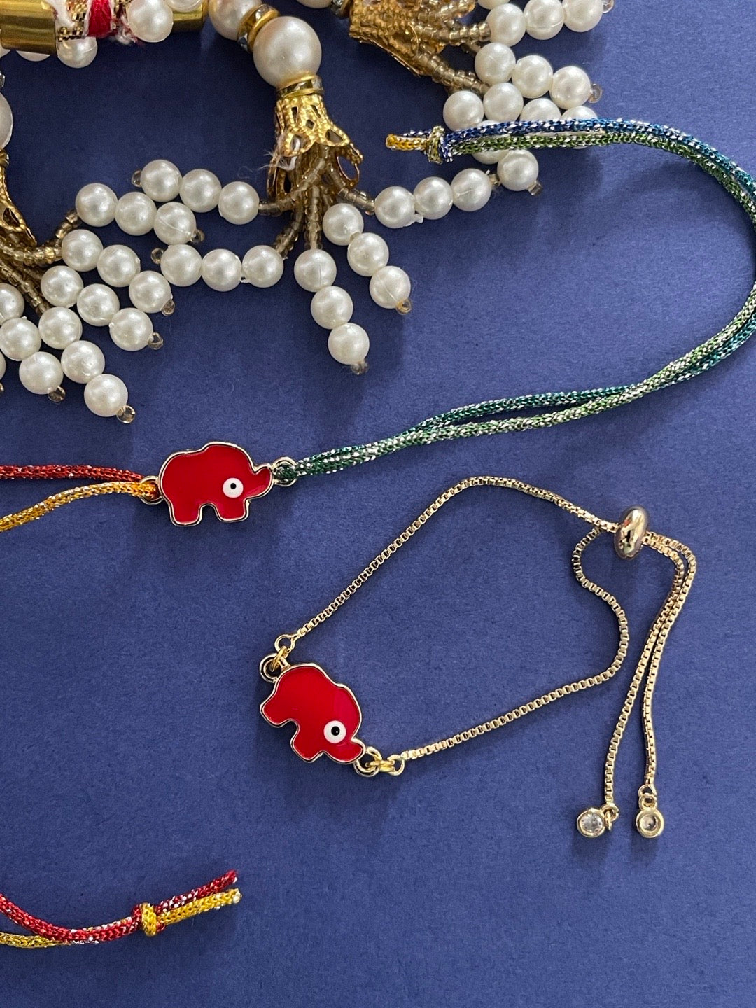 image for (Rakhi Set of 2) Fancy Red Elephant Enamel Evil Eye Rakhi Thread And Bracelet For Brother-Bhabhi