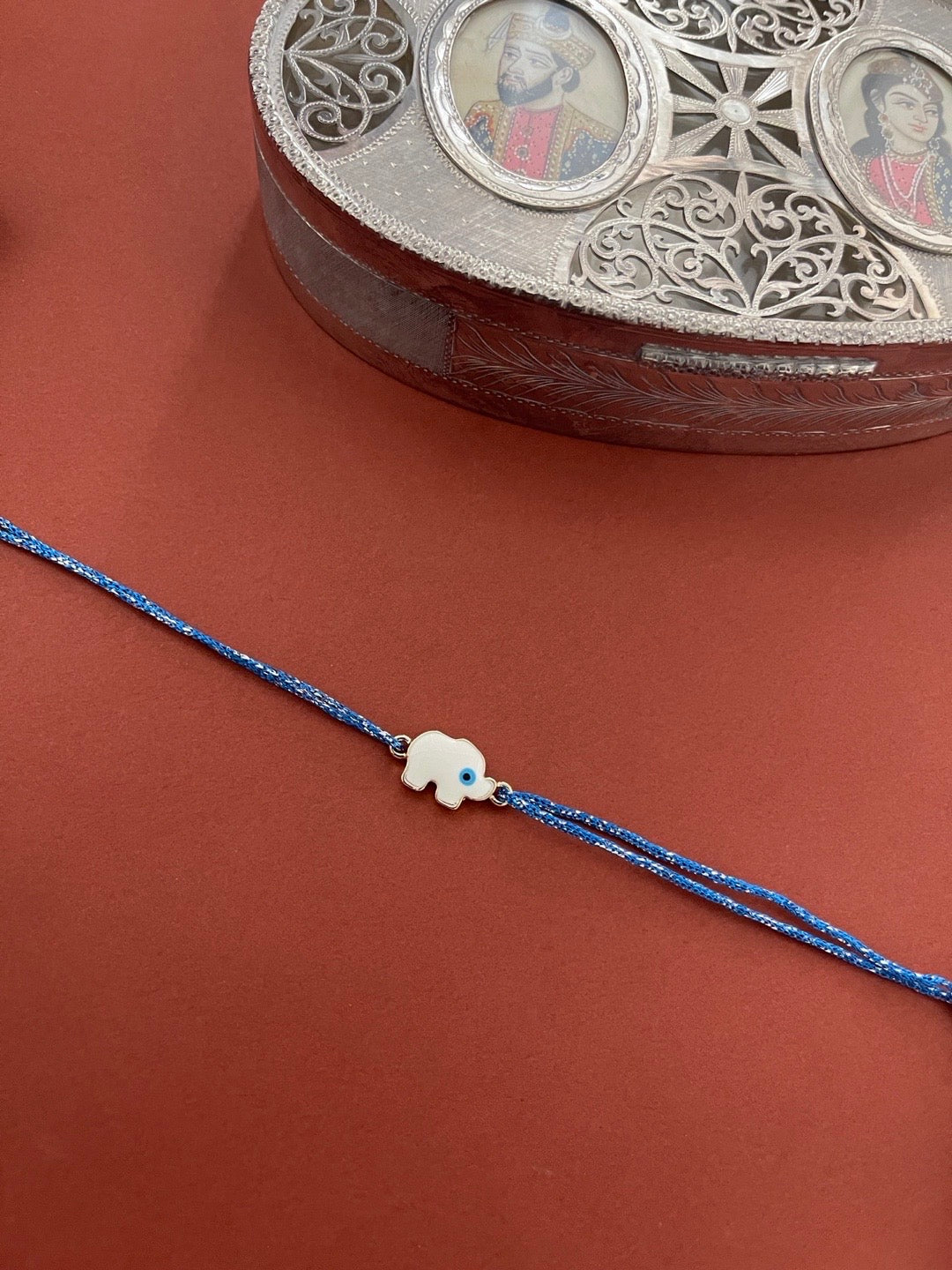 image for Fancy Designer Rakhi White Elephant Evil Eye Charm With Blue Thread Rakhi For Rakshabandhan