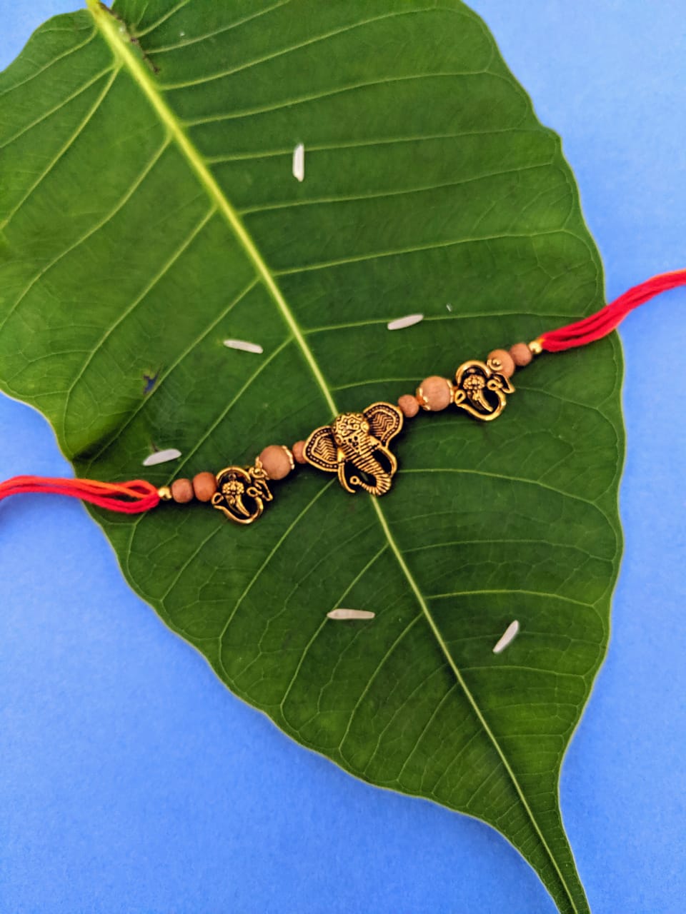 image for Latest Rakhi Design Gold Plated OM/Ganesha Face with Tulsi Beads Pendant Mauli Raksha Bandhan