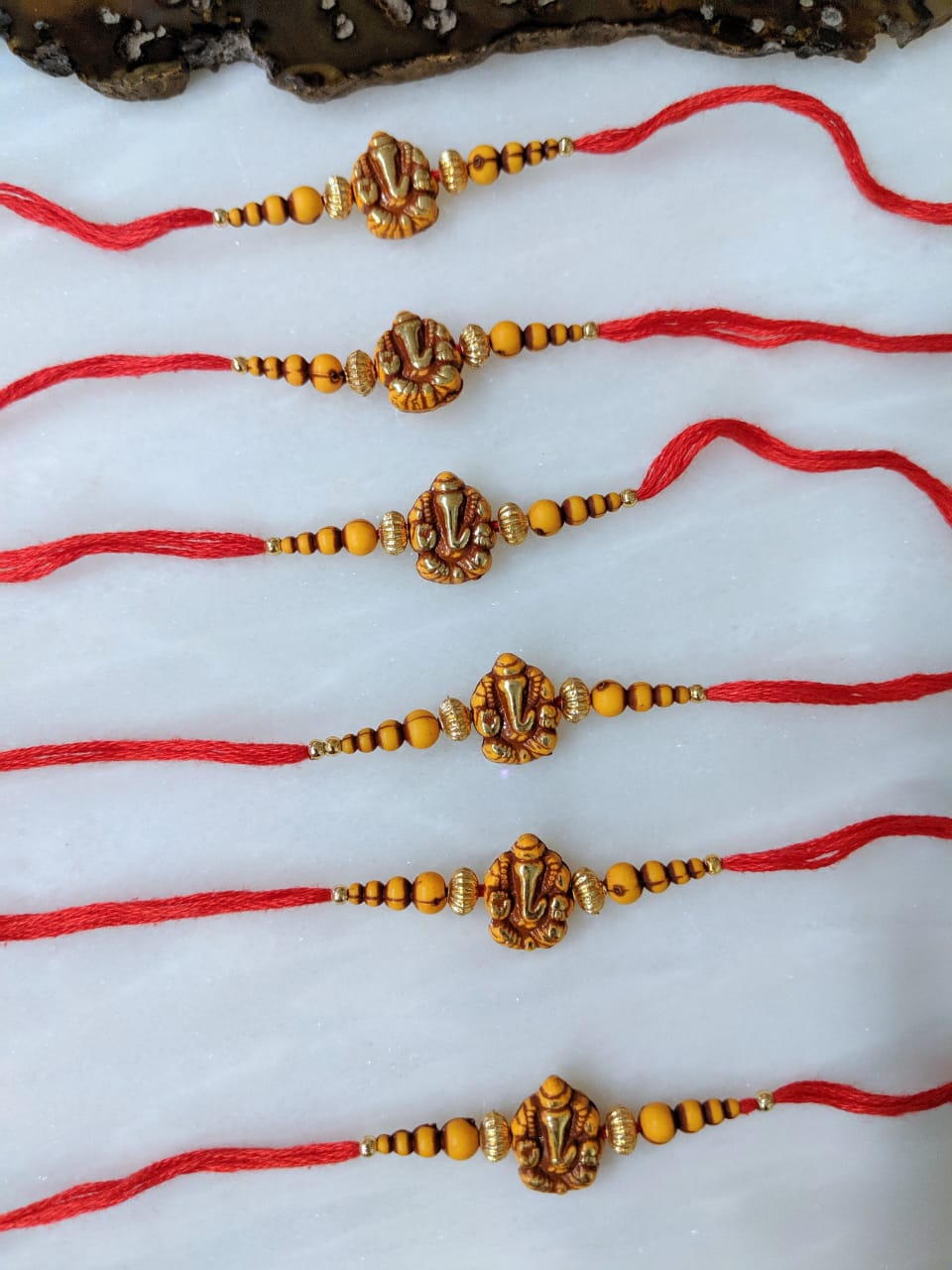 image for (Set of 6) Ganesh Ji Rakhi for Men Gold Yellow Beads Red Thread Rakhi