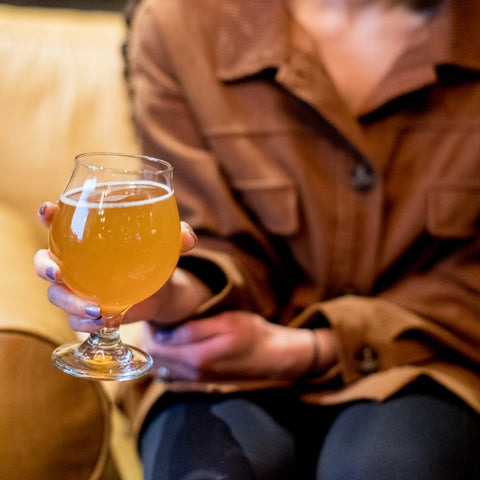 Femme tenant un verre à bière belge classique Libbey Craft Brews
