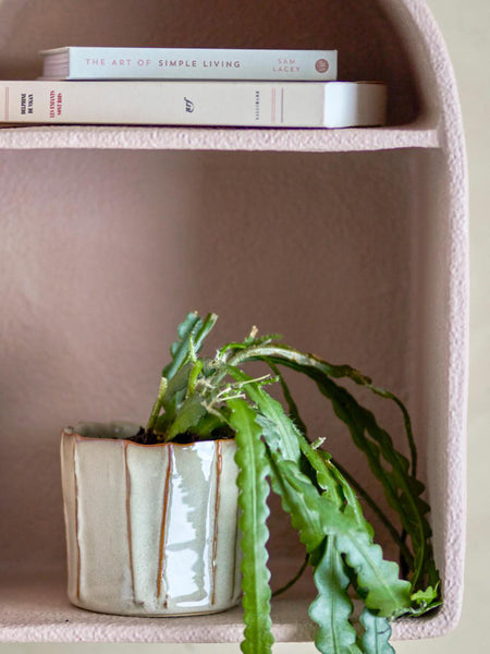 glazed white decorative plant pot on funky pink shelf
