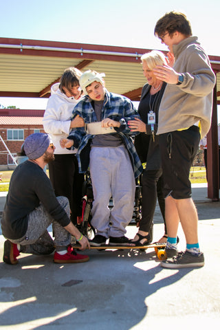 Helping Disabled Child Stand on a Longboard for the First Time