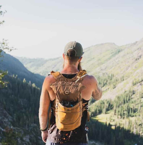 Man looking at view wearing Orange Mud Adventure Backpack