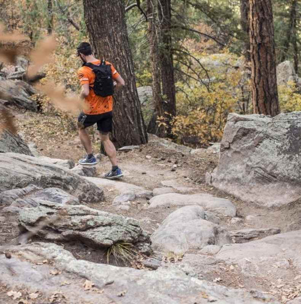 Man wearing orange mud adventure pack while running